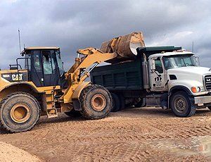 CAT wheel loader loading material into a dump truck at Cheaper Than Dirt Landscape Supply yard